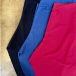 Folded Salmastra swimsuits in midnight blue, light blue and red