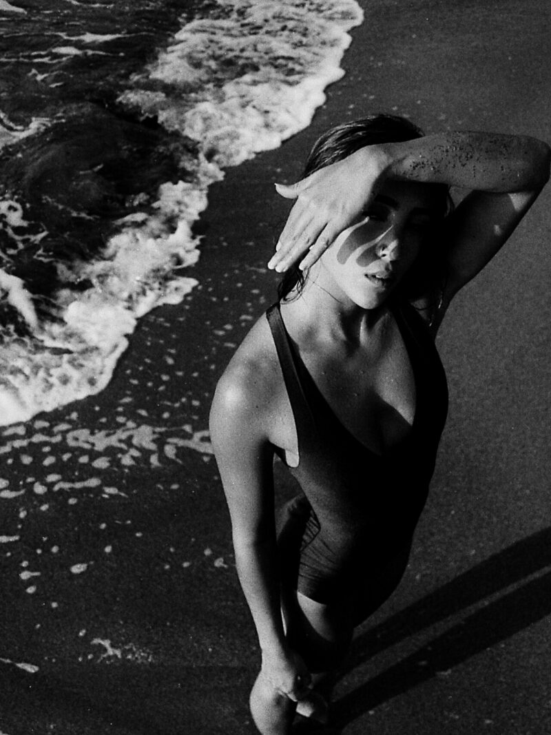 Woman in a one-piece at the water’s edge, black and white photo