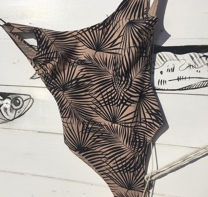 Costume intero a foglie di palma appeso a un muro dipinto