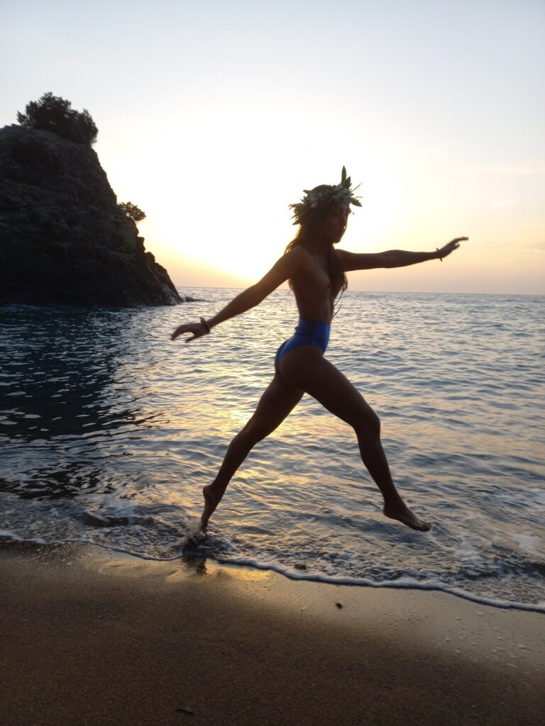 Girl running along the shore at sunset