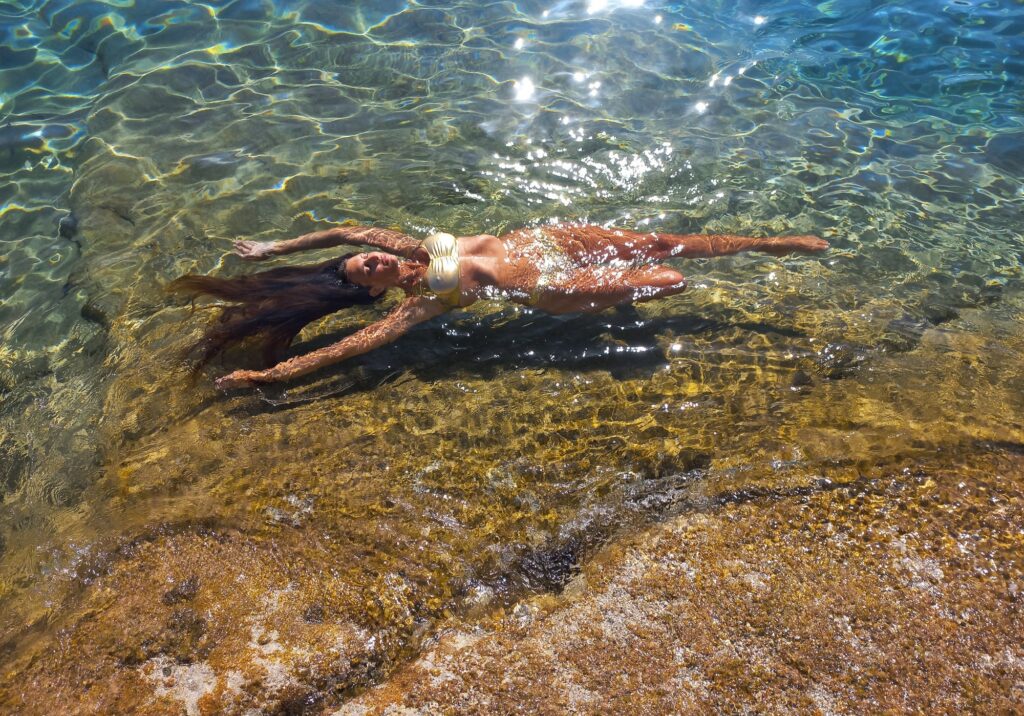 Girl swimming in shallow, clear water