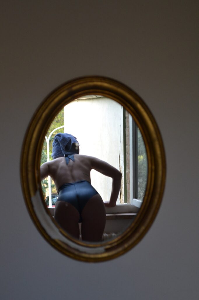 Blue swimsuit seen in an oval mirror