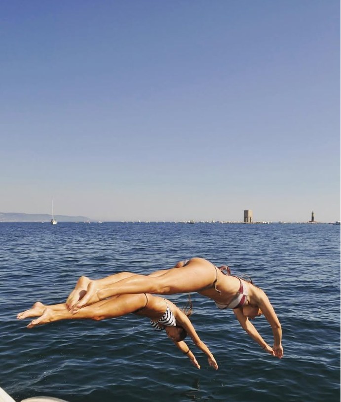 Two girls diving into the open sea