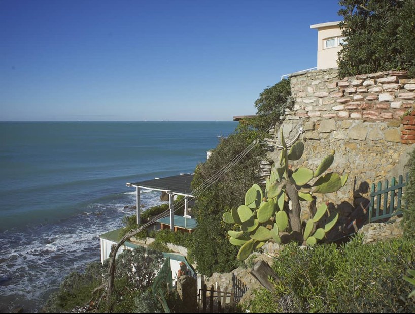 Cliff with a house by the sea and prickly pears