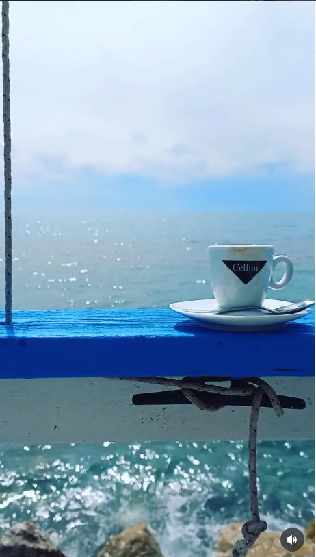 Espresso cup on the railing, with the sea below