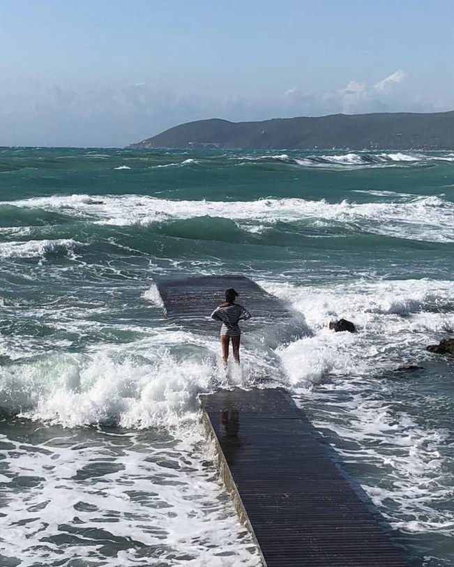Girl on the pier among the waves
