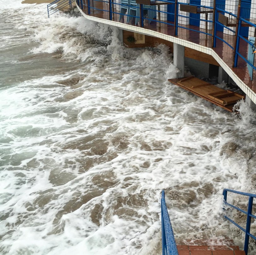 Waves crashing against a beach club by the sea