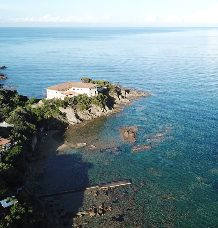 Headland with a white house by the sea, seen from above