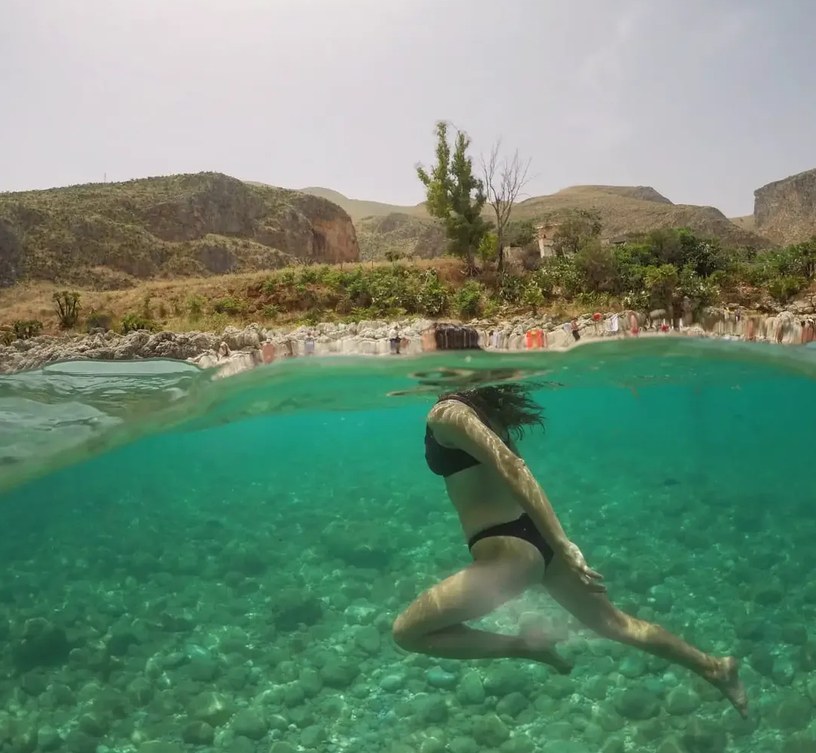 Girl swimming in green water, half above and half below
