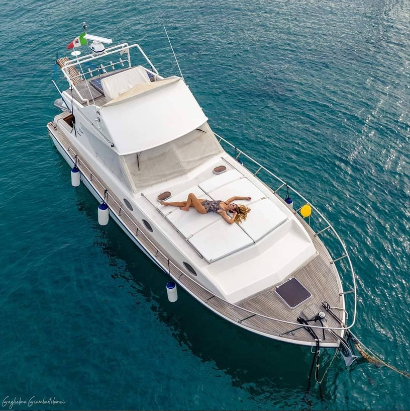 Girl in the sun on a boat, seen from above